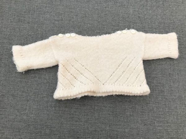 vit stickad tröja med 3 vita knappar på vardera axel, som passar bebisar 0-3 månader