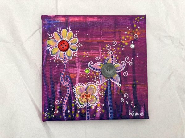 Konstnären Linda Gartman har skapat en canvas tavla med knappar, blommiga motiv i cerisefärgade toner.
